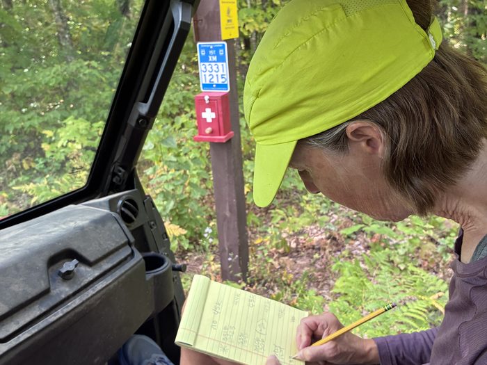 A volunteer the location of an emergency location sign.